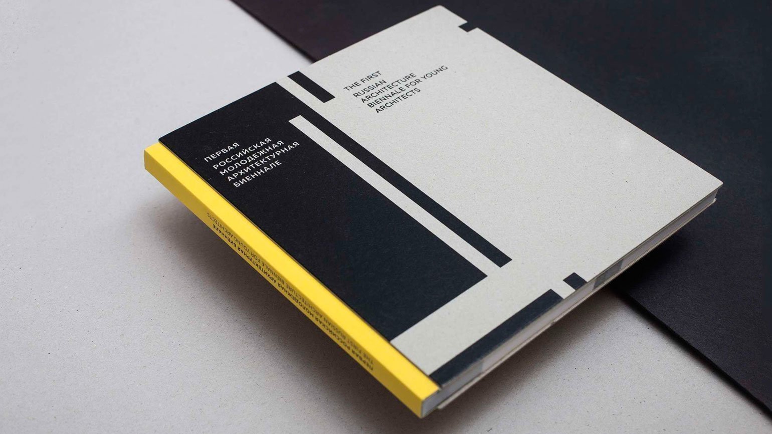 книга с жёлтым корешком и серой обложкой с чёрными прямоугольниками