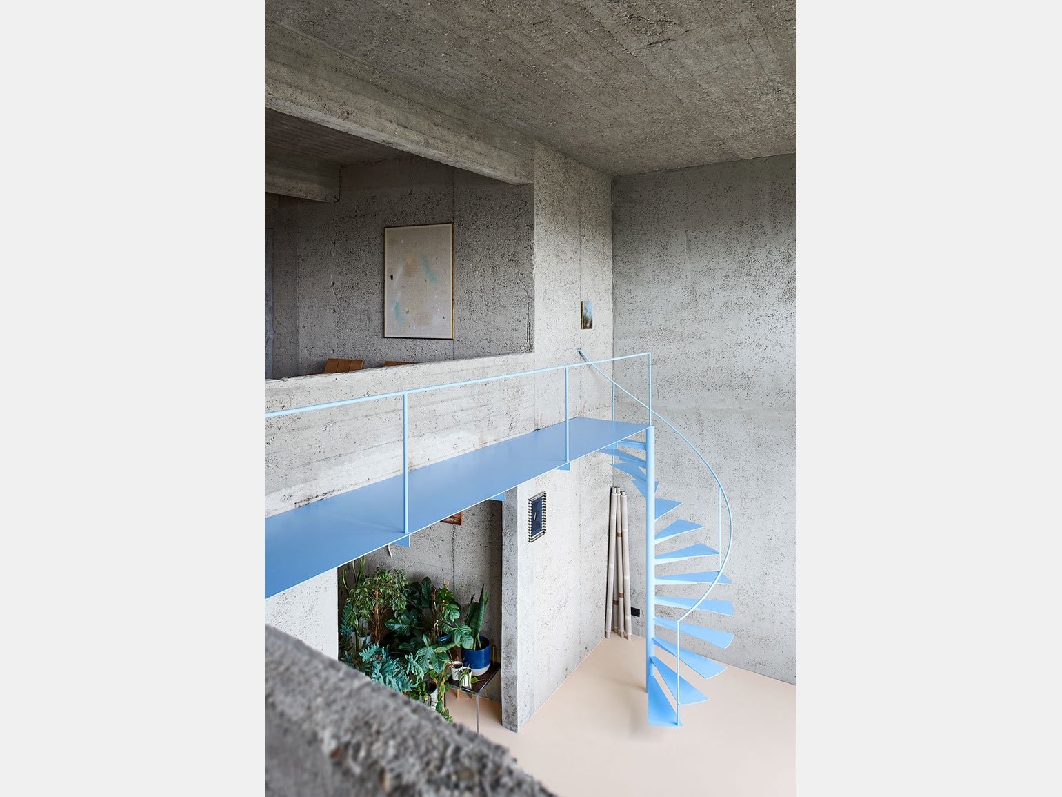 интерьер в стиле лофт с бетонными стенами и металлической лестницей
