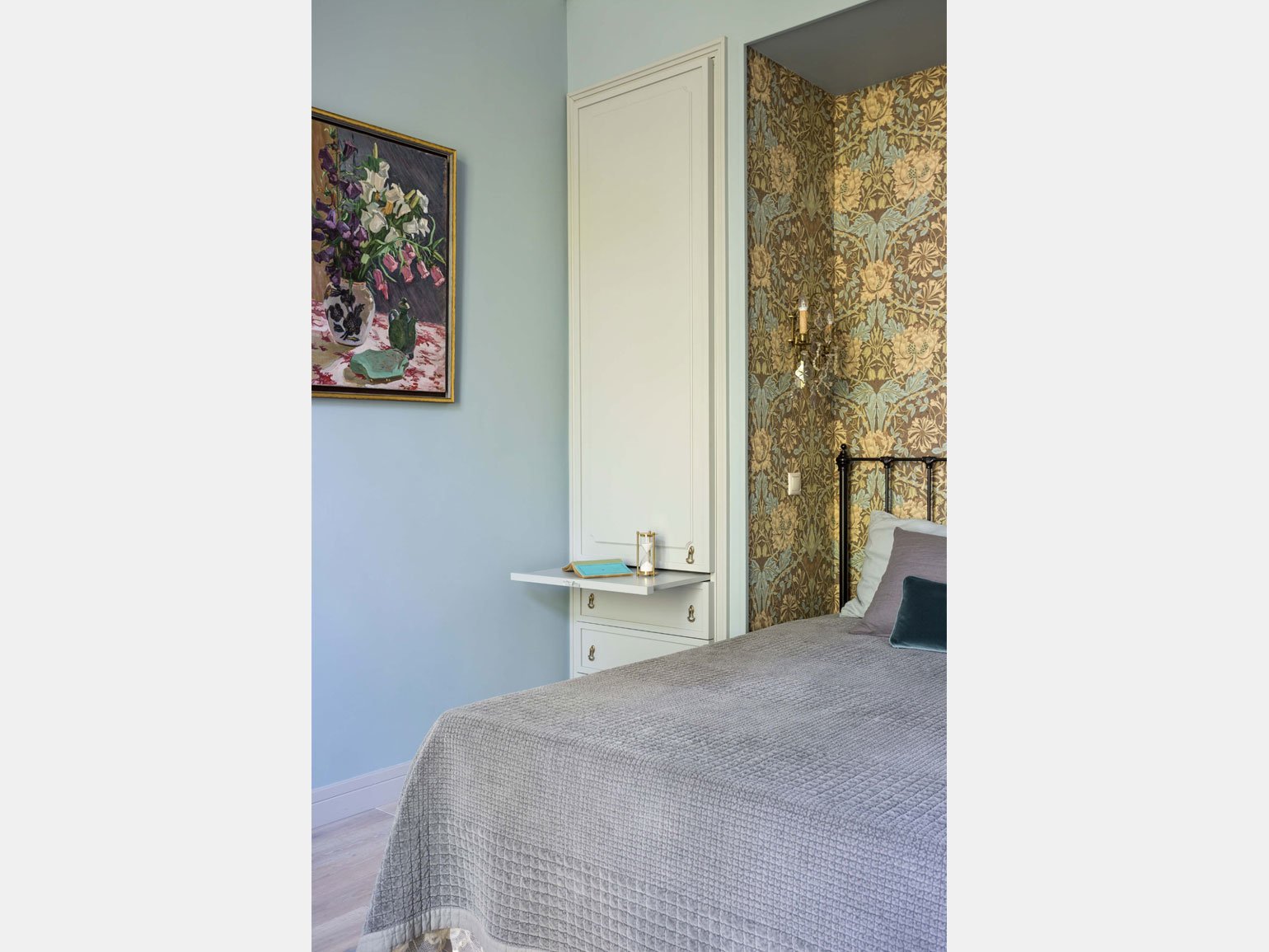 классический интерьер спальни с голубыми стенами, обоями с цветами, белыми дверями и серым покрывалом