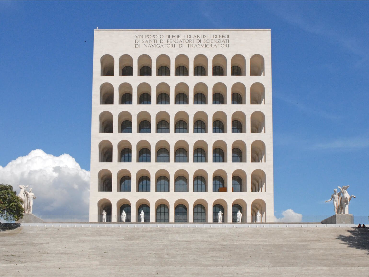 На фоне голубого неба шестиэтажное бежевое здание в Риме